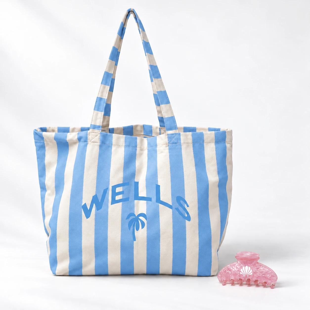 Kira striped blue tote with a pink claw clip